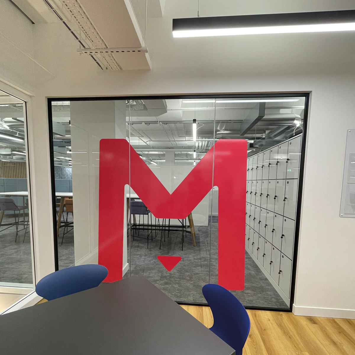Large red Medivet 'M' logo on office glass screen
