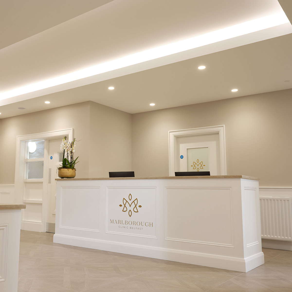 White reception desk with gold practice logo